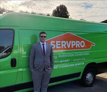 Business Development Manager standing in front of the SERVPRO Adamstown Promaster Van 