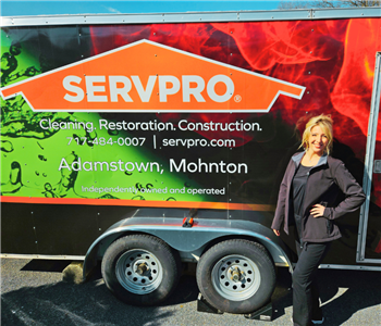 A new SERVPRO employee stands in front of a colorful SERVPRO trailer.