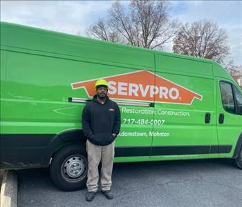 SERVPRO male employee stands in front of SERVPRO van